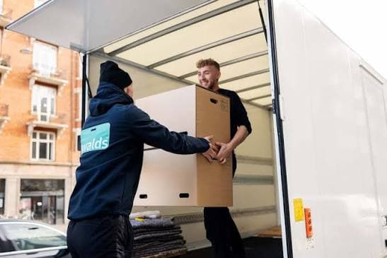 Two movers loading boxes into a moving truck